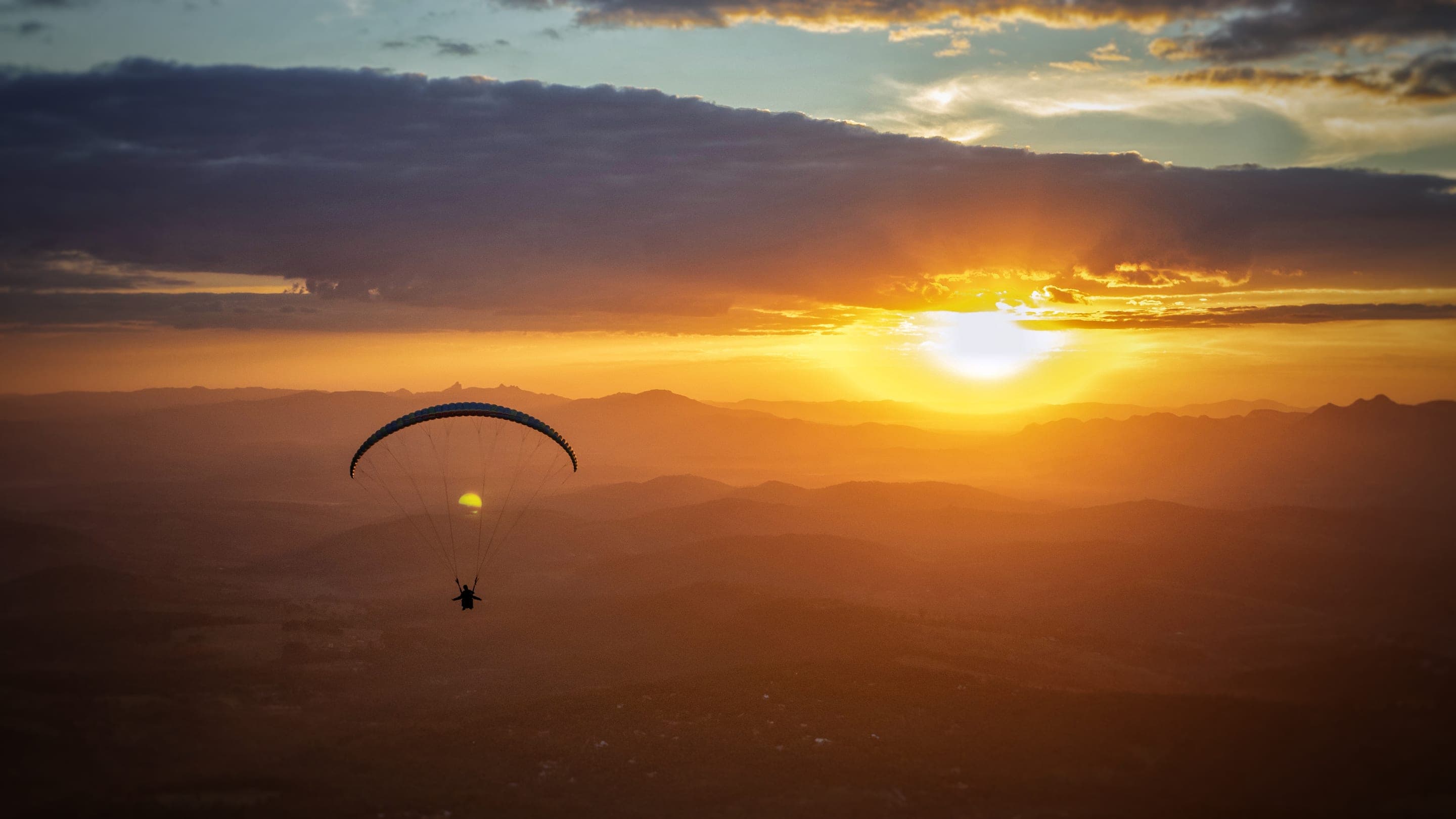 Parapente ao pôr do sol sobre a Serra da Moeda